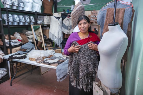 Gladys mostrando la cadena de valor de la alpaca con prendas finalizadas_11zon